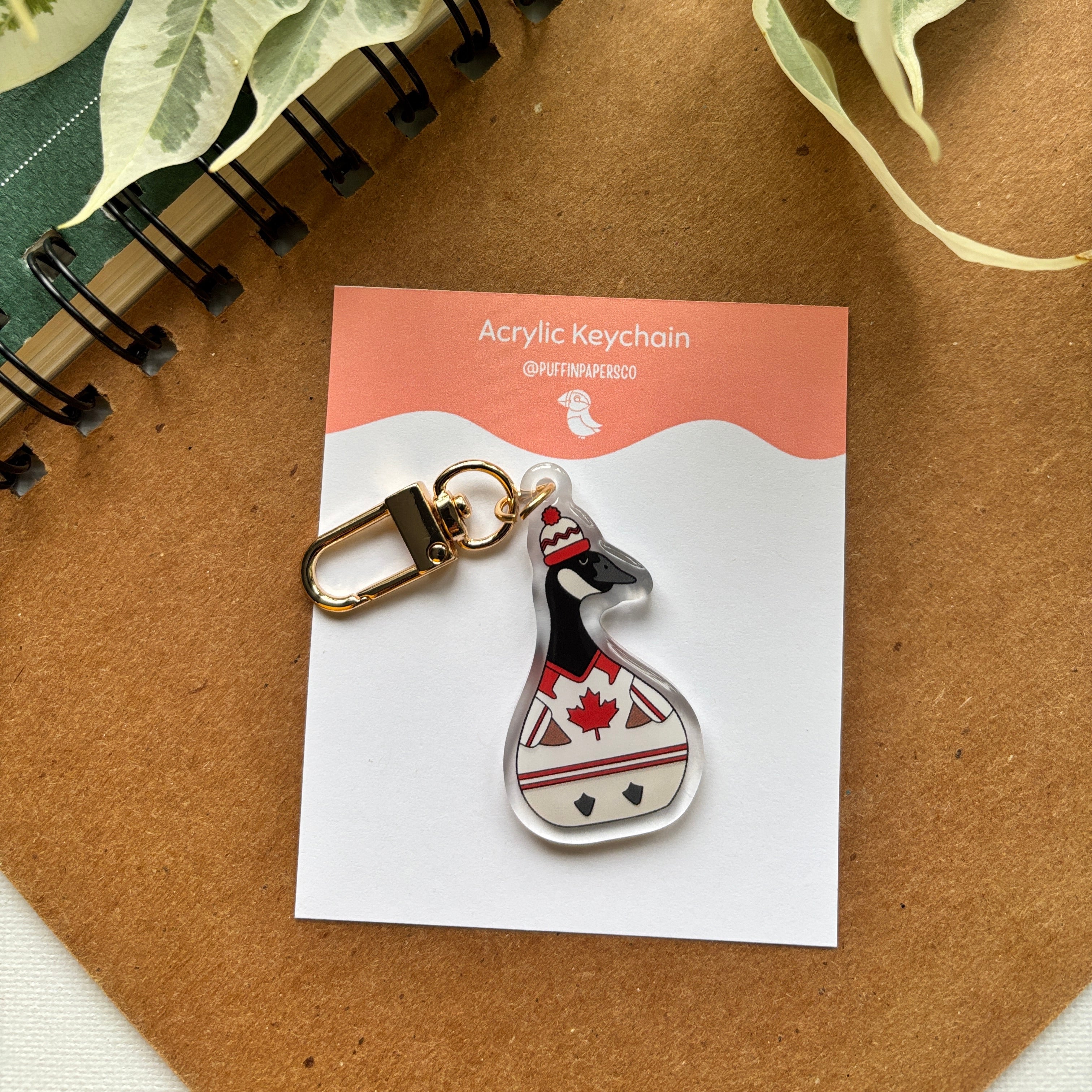 Acrylic keychain of a canadian goose wearing a hockey jersey with a backing on it